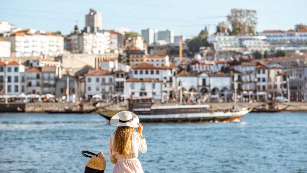 A girl is sitting on the Duoro river coast