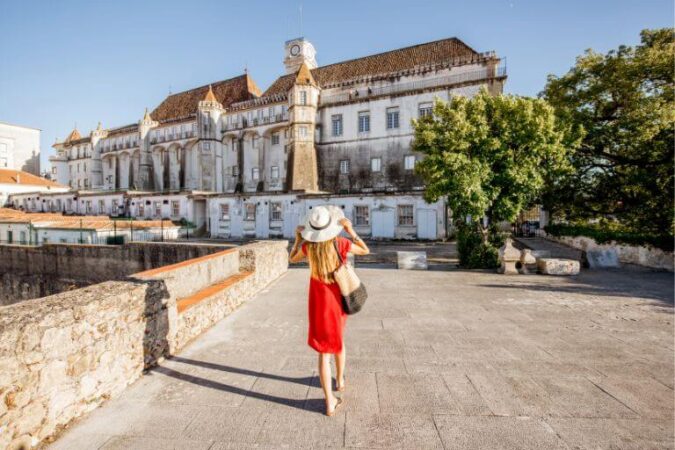 A woman in red dress exploring Coimbra during her tour to Portugal
