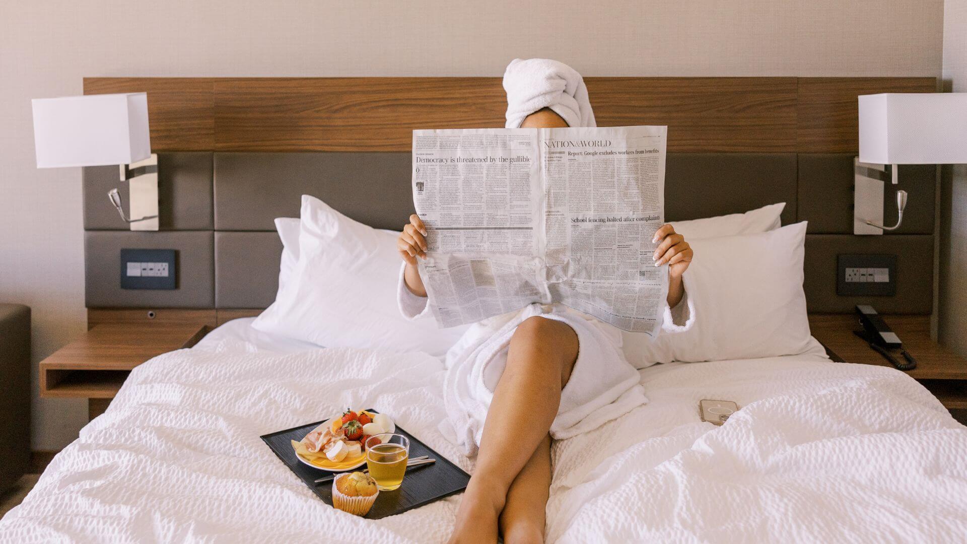 A woman in a hotel treating herself to a breakfast in bed