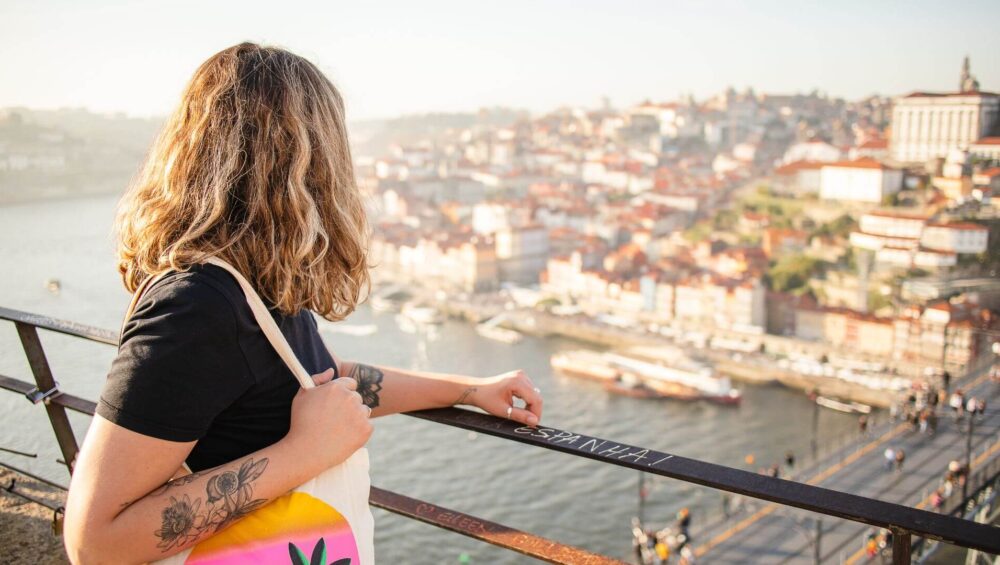 A woman with a tote bag admiring the views of Lisbon from a viewpoint