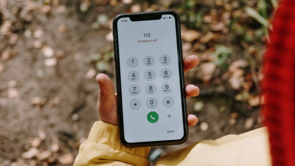 A person holding a phone with dialed emergency number