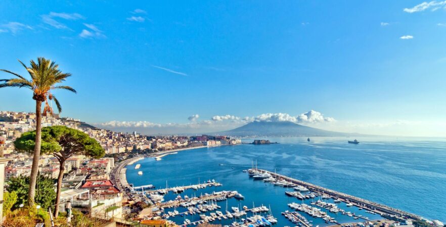 A cup of coffee on a balcony rail, overlooking Naples and striking Vesuvius, a must-see during the Italy vacation