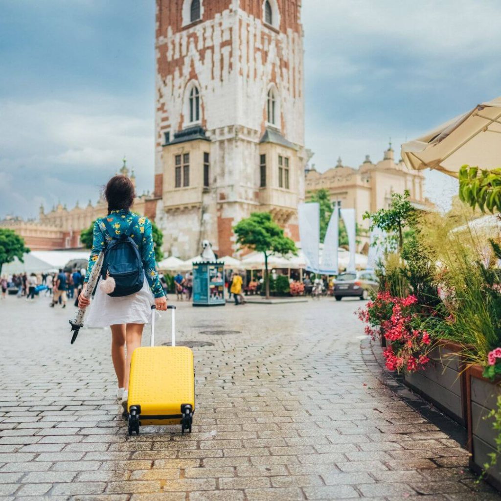 A woman with a yellow suitcase enjoying her solo vacation